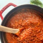 Turkey meat sauce in a staub dutch oven with a wooden spoon in the sauce