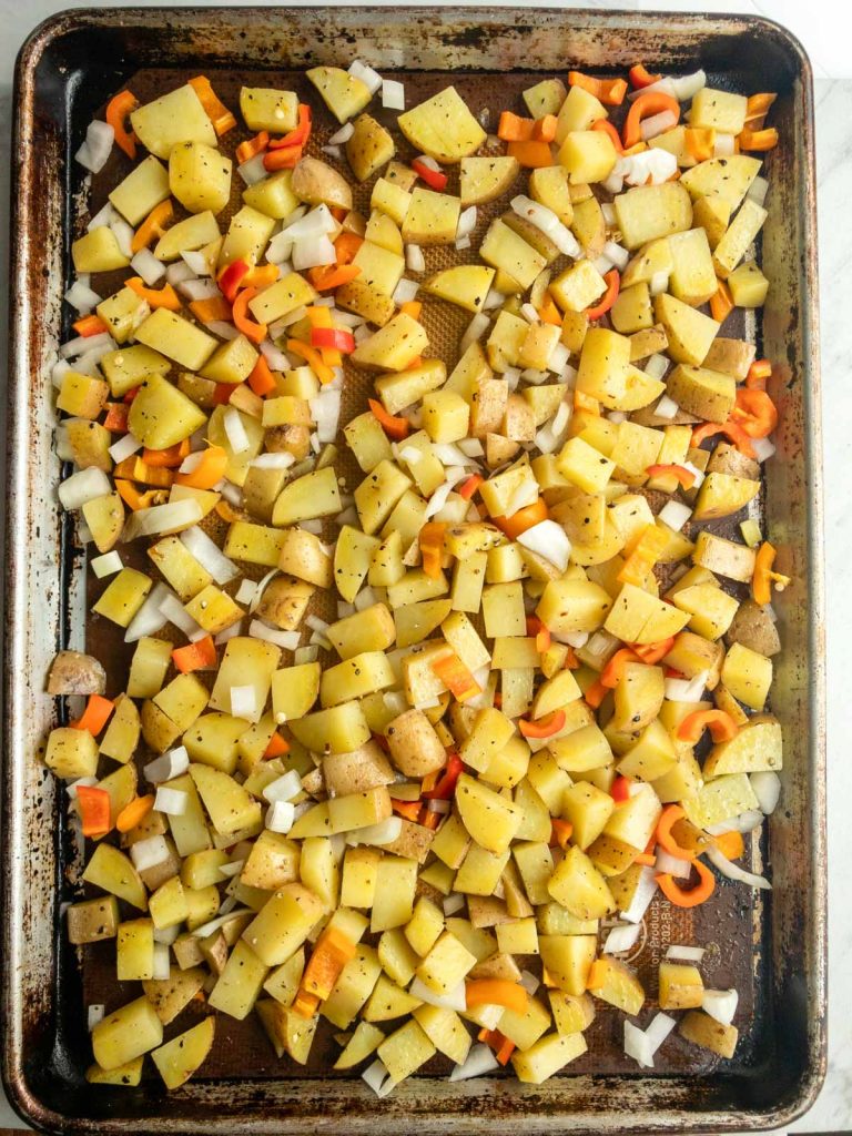 diced potatoes and onions and peppers on a sheet pan