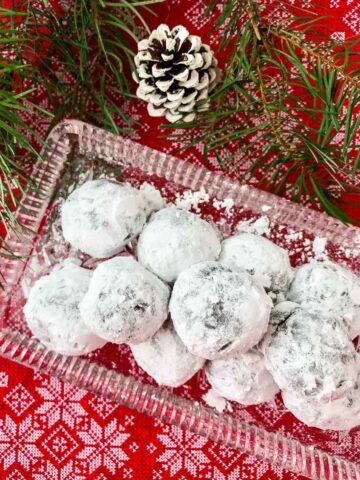 Rum balls on glass plate with white pine cone, pine tree branch