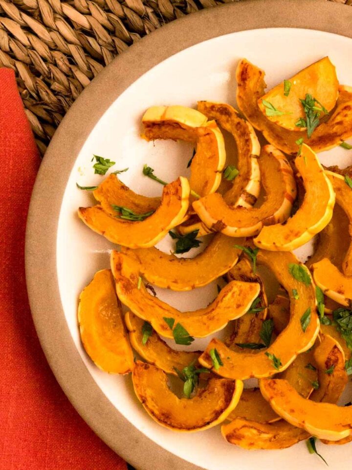 Roasted delicata squash slices on a tan plate