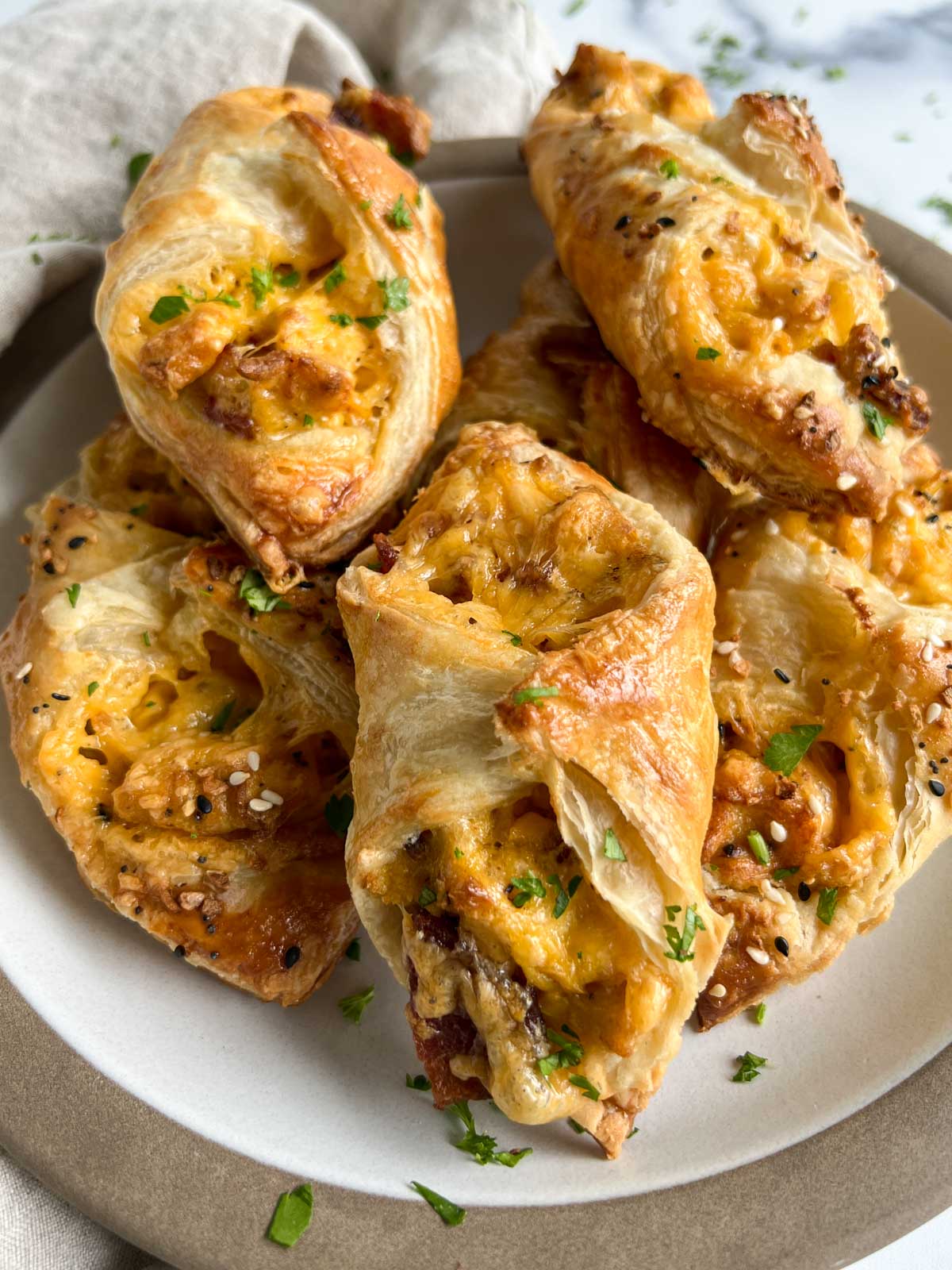 Egg, bacon, cheese wrapped in puff pastry on a plate