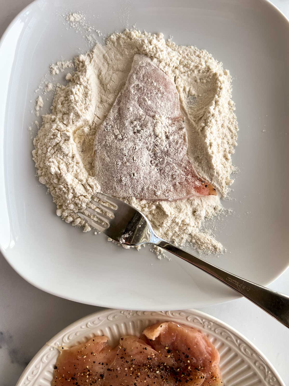 Chicken breast on a plate with flour