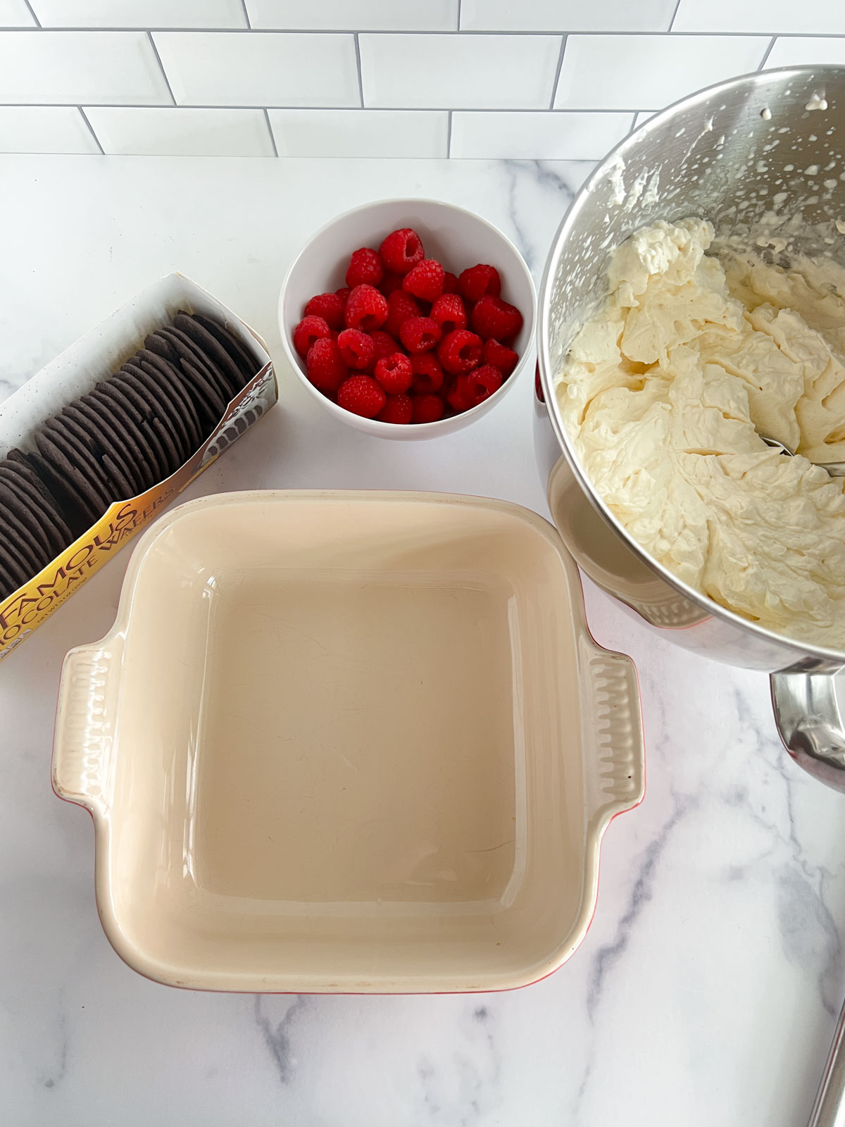 Chocolate wafers in a box, raspberries in a bowl, whipped cream in a bowl, 8 inch by 8 inch square pan