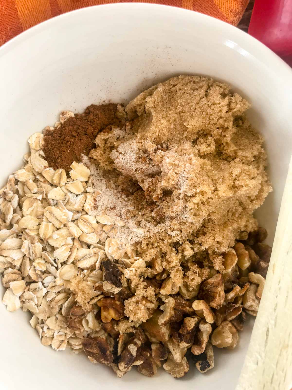 Oatmeal, whole wheat flour cinnamon and brown sugar in a white  bowl