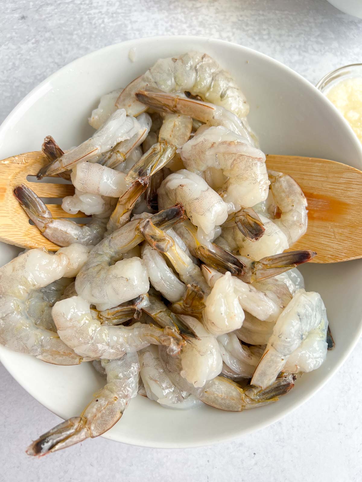 Raw Shrimp in a bowl, with salad tongs