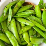 cooked sugar snap peas in a white bowl