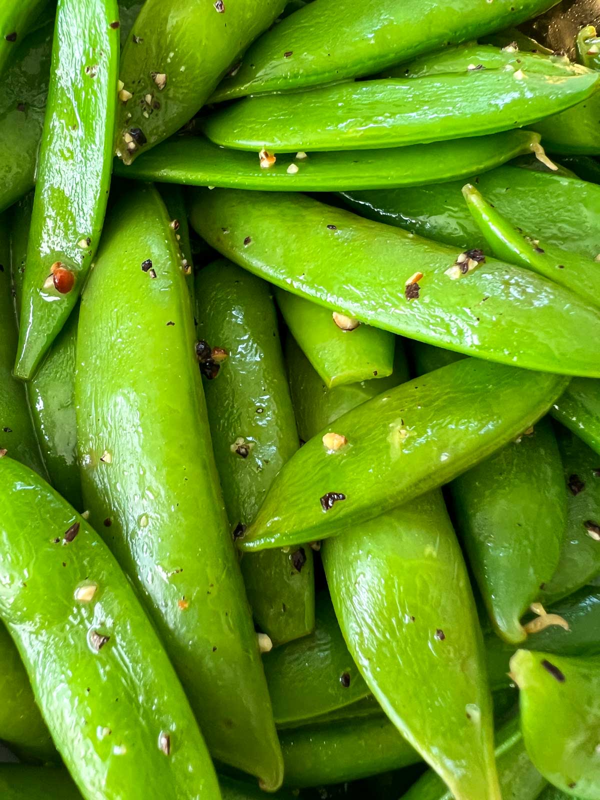 closeup of sugar snap peas with butter, salt and pepper