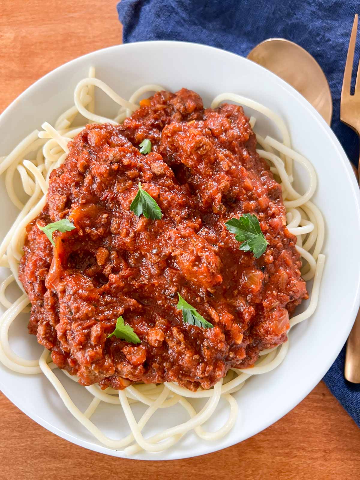 tukey meat sauce on top of spaghetti noodles in a white bowl