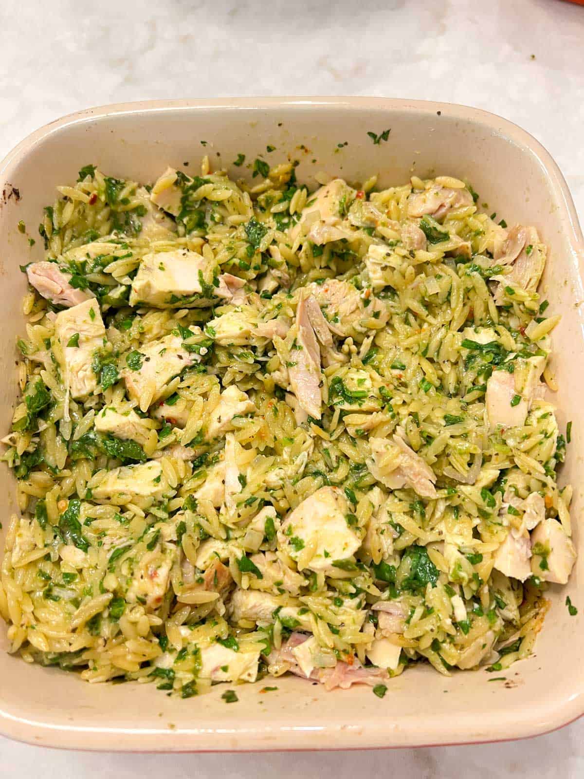 Chicken with orzo, spinach, pesto in a casserole dish