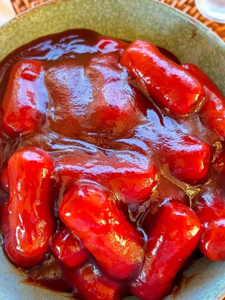 Little smokies hot dogs in bbq sauce in a blue bowl