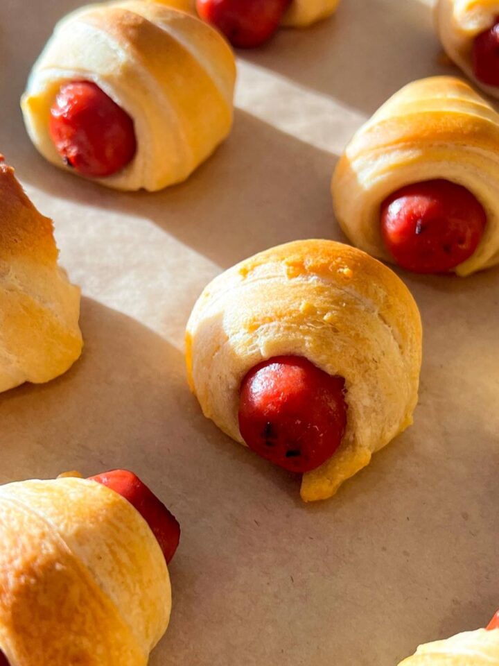 little smokies pigs in a blanket on a sheet pan lined with parchment paper
