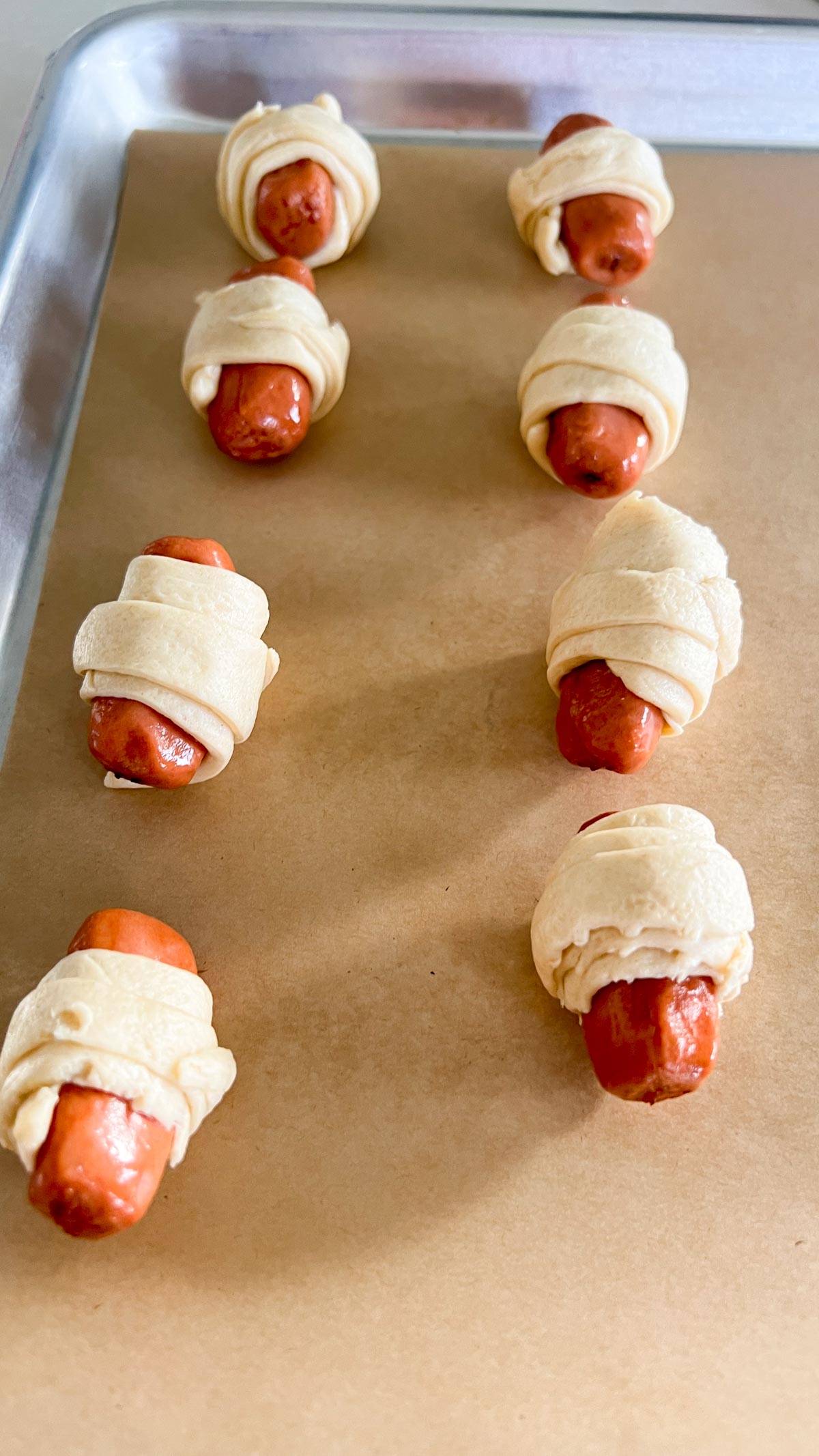 Pigs in a blanket on a sheet pan ready to go in the oven